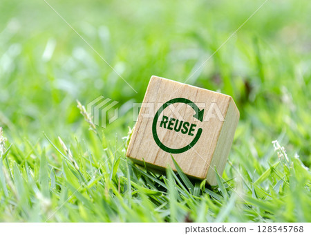 Wooden cube tilted on grass with reuse icon Wooden cube tilted on grass with reuse icon 128545768
