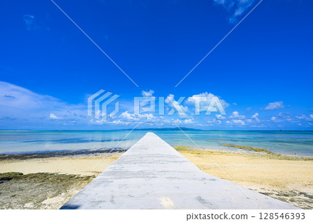 Taketomi Island West Pier leading straight into the sea. A view of the emerald sea and a straight white pier. Taketomi Island West Pier leading straight into the sea. A view of the emerald sea and a straight white pier. 128546393