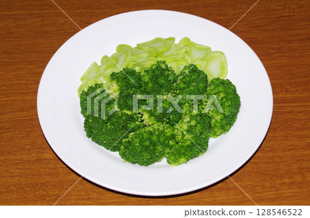 Fresh, beautiful green broccoli cut into bite-sized pieces and boiled, served on a plate (wood grain background) Fresh, beautiful green broccoli cut into bite-sized pieces and boiled, served on a plate (wood grain background) 128546522