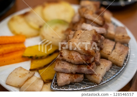 Grilled Samgyupsal, a popular Korean dish consisting of thick, sliced pork belly cooked on the grill 128546557