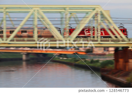 Sleeper express train Cassiopeia crossing the Shingashi River at dusk Sleeper express train Cassiopeia crossing the Shingashi River at dusk 128546773