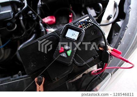 Car battery being tested with a battery tester, vehicle maintenance with diagnostic tool. Car battery being tested with a battery tester, vehicle maintenance with diagnostic tool. 128546811