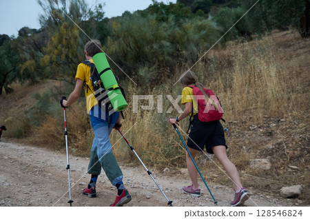Active Couple Hiking in Nature Carrying Trekking Gear Active Couple Hiking in Nature Carrying Trekking Gear 128546824