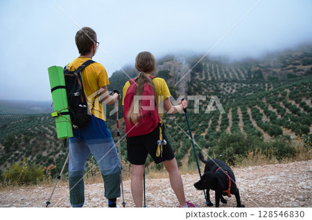 Couple Enjoying a Scenic Mountain Hike with Their Dog in Nature Couple Enjoying a Scenic Mountain Hike with Their Dog in Nature 128546830