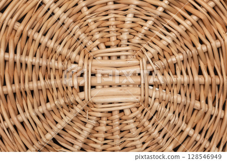 Woven Wicker Basket With Intricate Texture Displayed Against a Simple Background 128546949