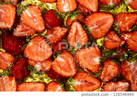 Halves of fresh ripe strawberries in water, summer juicy fruit berry background. Halves of fresh ripe strawberries in water, summer juicy fruit berry background. 128546994