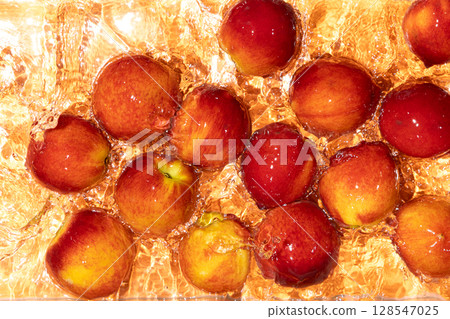 Whole Ripe Peaches in Water. Top View with Ripples and Splash. 128547025