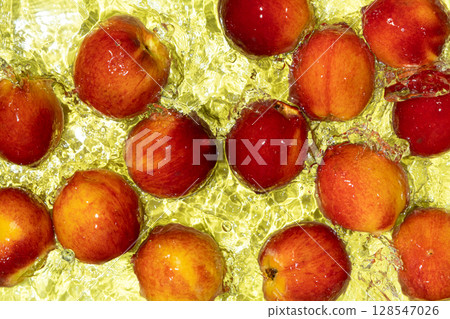 Whole Ripe Peaches in Water. Top View with Ripples and Splash. 128547026