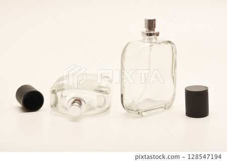 Empty glass perfume bottle. Elegant transparent flacon once filled with fragrance, now standing clean and minimalistic, ideal for cosmetics or beauty-related concepts. Empty glass perfume bottle. Elegant transparent flacon once filled with fragrance, now standing clean and minimalistic, ideal for cosmetics or beauty-related concepts. 128547194