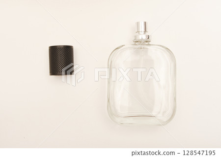 Empty glass perfume bottle. Elegant transparent flacon once filled with fragrance, now standing clean and minimalistic, ideal for cosmetics or beauty-related concepts. 128547195