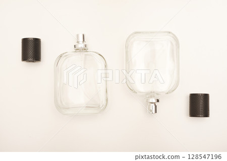 Empty glass perfume bottle. Elegant transparent flacon once filled with fragrance, now standing clean and minimalistic, ideal for cosmetics or beauty-related concepts. 128547196
