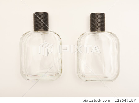 Empty glass perfume bottle. Elegant transparent flacon once filled with fragrance, now standing clean and minimalistic, ideal for cosmetics or beauty-related concepts. Empty glass perfume bottle. Elegant transparent flacon once filled with fragrance, now standing clean and minimalistic, ideal for cosmetics or beauty-related concepts. 128547197