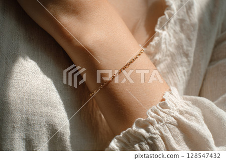 Minimalist gold bracelet on female wrist 128547432