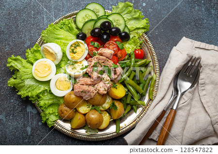 Nicoise salad with tuna, olives, green beans, tomatoes and quail eggs on a bed of lettuce Nicoise salad with tuna, olives, green beans, tomatoes and quail eggs on a bed of lettuce 128547822