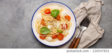 Spaghetti with cherry tomatoes and mozzarella being served on a plate with copy space Spaghetti with cherry tomatoes and mozzarella being served on a plate with copy space 128547852