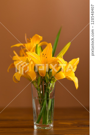 Fresh bouquet of orange lilies on a brown background 128548407