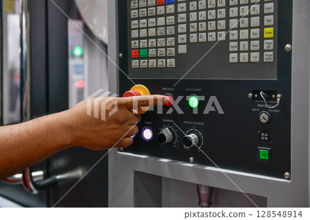 Machine operator hand turns on control panel of industrial machine. technician push button on control panel 128548914