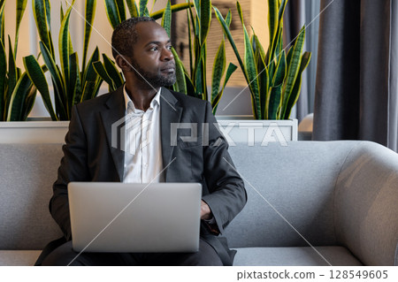 Businessman working on a laptop and looking busy and thoughtful Businessman working on a laptop and looking busy and thoughtful 128549605