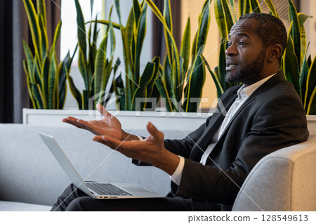 Businessman with a laptop having a talk and looking emotional 128549613