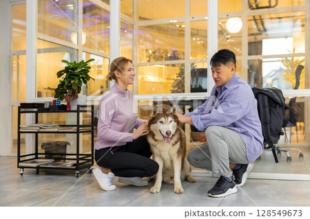 Two colleagues in a coworking area with a dog 128549673