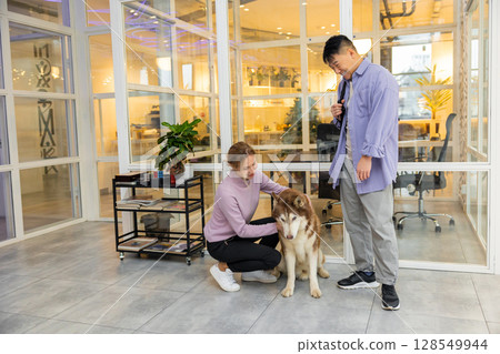 Two colleagues in a coworking area with a dog 128549944