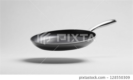 A simple black frying pan floating in the air, contrasting with a metal handle A simple black frying pan floating in the air, contrasting with a metal handle 128550309