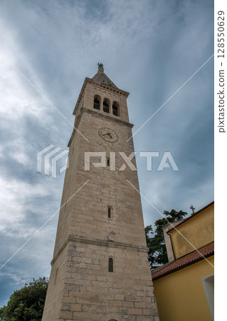 Stone bell tower with clock in Novigrad, Croatia. 128550629