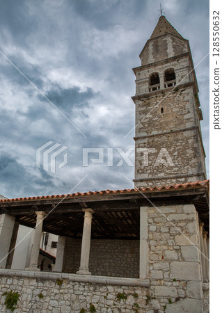 Medieval bell tower rising above stone colonnade in Visnjan, Croatia. 128550632
