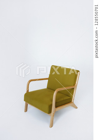 Green cushioned armchair with wooden frame on white background with copy space 128550701