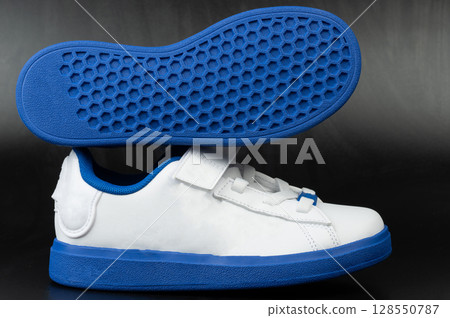 White and blue casual shoes with unique sole design displayed prominently 128550787