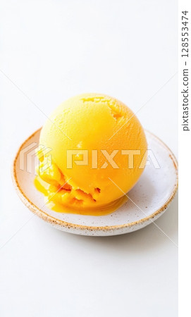 Fresh exotic dessert - mango scoop styled on white, perfect for summer food banners, vegan menus, or minimalist packaging. 128553474