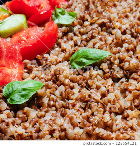 Healthy food without meat with buckwheat and a salad of chopped tomatoes, cucumbers, onions and basil leaves. The photo is suitable for the topic of healthy lifestyle and healthy eating Healthy food without meat with buckwheat and a salad of chopped tomatoes, cucumbers, onions and basil leaves. The photo is suitable for the topic of healthy lifestyle and healthy eating 128554121
