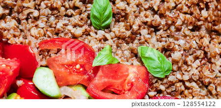 Healthy food without meat with buckwheat and a salad of chopped tomatoes, cucumbers, onions and basil leaves. The photo is suitable for the topic of healthy lifestyle and healthy eating Healthy food without meat with buckwheat and a salad of chopped tomatoes, cucumbers, onions and basil leaves. The photo is suitable for the topic of healthy lifestyle and healthy eating 128554122