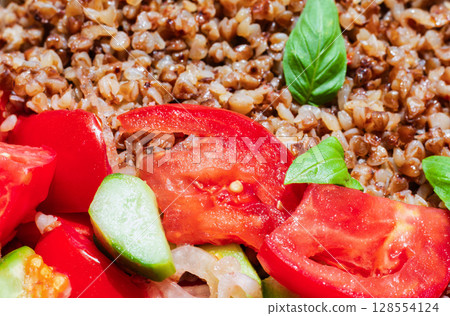 Healthy food without meat with buckwheat and a salad of chopped tomatoes, cucumbers, onions and basil leaves. The photo is suitable for the topic of healthy lifestyle and healthy eating Healthy food without meat with buckwheat and a salad of chopped tomatoes, cucumbers, onions and basil leaves. The photo is suitable for the topic of healthy lifestyle and healthy eating 128554124