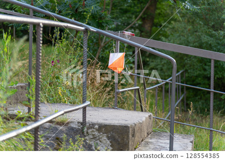 Street orienteering control point with a prism and electric composter attached to metal railings. Street orienteering control point with a prism and electric composter attached to metal railings. 128554385