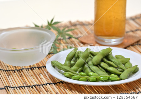 Delicious edamame beans on a plate and beer Delicious edamame beans on a plate and beer 128554567