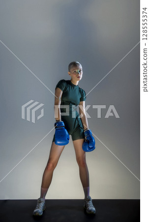 Sporty girl with boxing gloves Sporty girl with boxing gloves 128555374