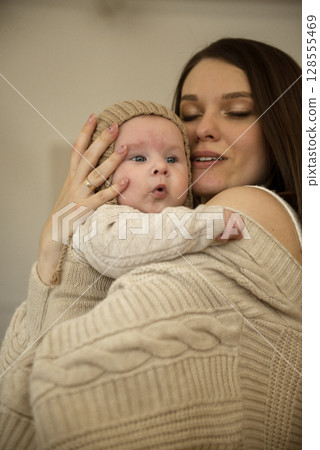 A woman holding a baby 128555469