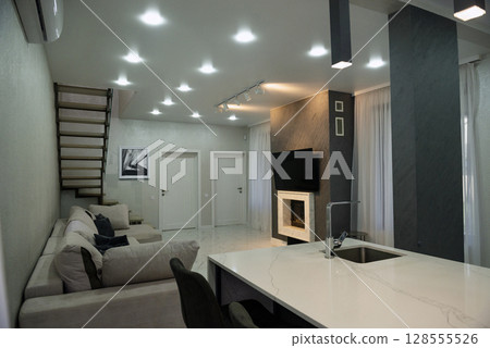 A room with a kitchen area and a fireplace. A room with a kitchen area and a fireplace. 128555526