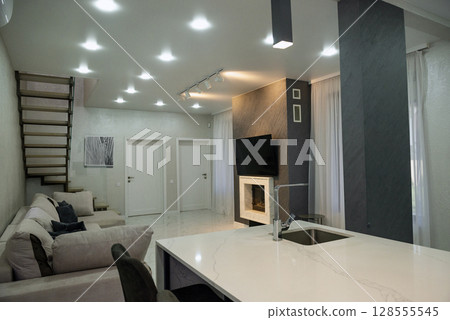 A room with a kitchen area and a fireplace. A room with a kitchen area and a fireplace. 128555545