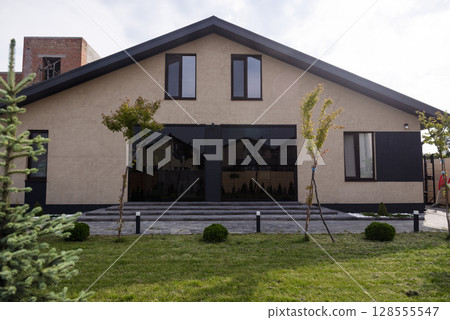Courtyard of a private house. one-story house, lawn, playground. Courtyard of a private house. one-story house, lawn, playground. 128555547