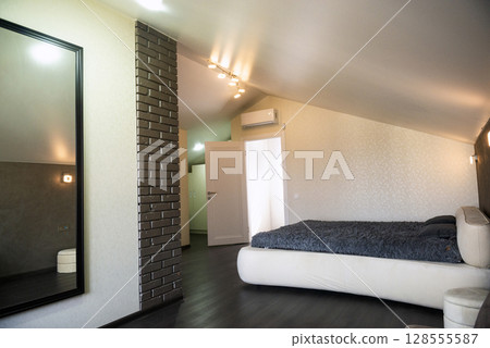 Bedroom with bed and window in the house. 128555587
