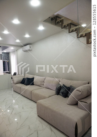 Living room. Light. There is a large sofa in the living room. Living room. Light. There is a large sofa in the living room. 128555615