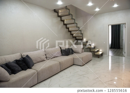 Living room. Light. There is a large sofa in the living room. Living room. Light. There is a large sofa in the living room. 128555616
