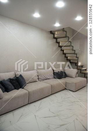Living room. Light. There is a large sofa in the living room. Living room. Light. There is a large sofa in the living room. 128555642