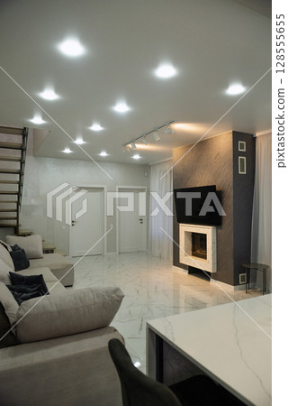 A room with a kitchen area and a fireplace. 128555655