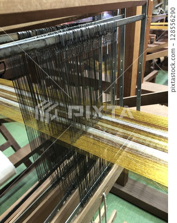 Wooden silk weaving machine in a workshop Wooden silk weaving machine in a workshop 128556290