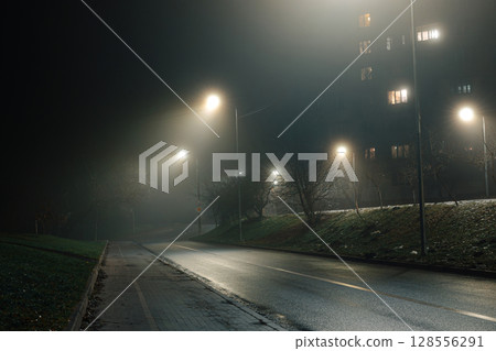 Empty Curved Road at Night with Fog and Streetlights 128556291