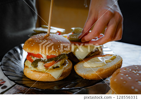 Homemade Cheeseburgers Being Prepared with Fresh Ingredients Homemade Cheeseburgers Being Prepared with Fresh Ingredients 128556331