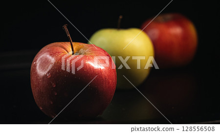 Three Apples in a Row on Black Background - Minimalist Fruit Composition Three Apples in a Row on Black Background - Minimalist Fruit Composition 128556508